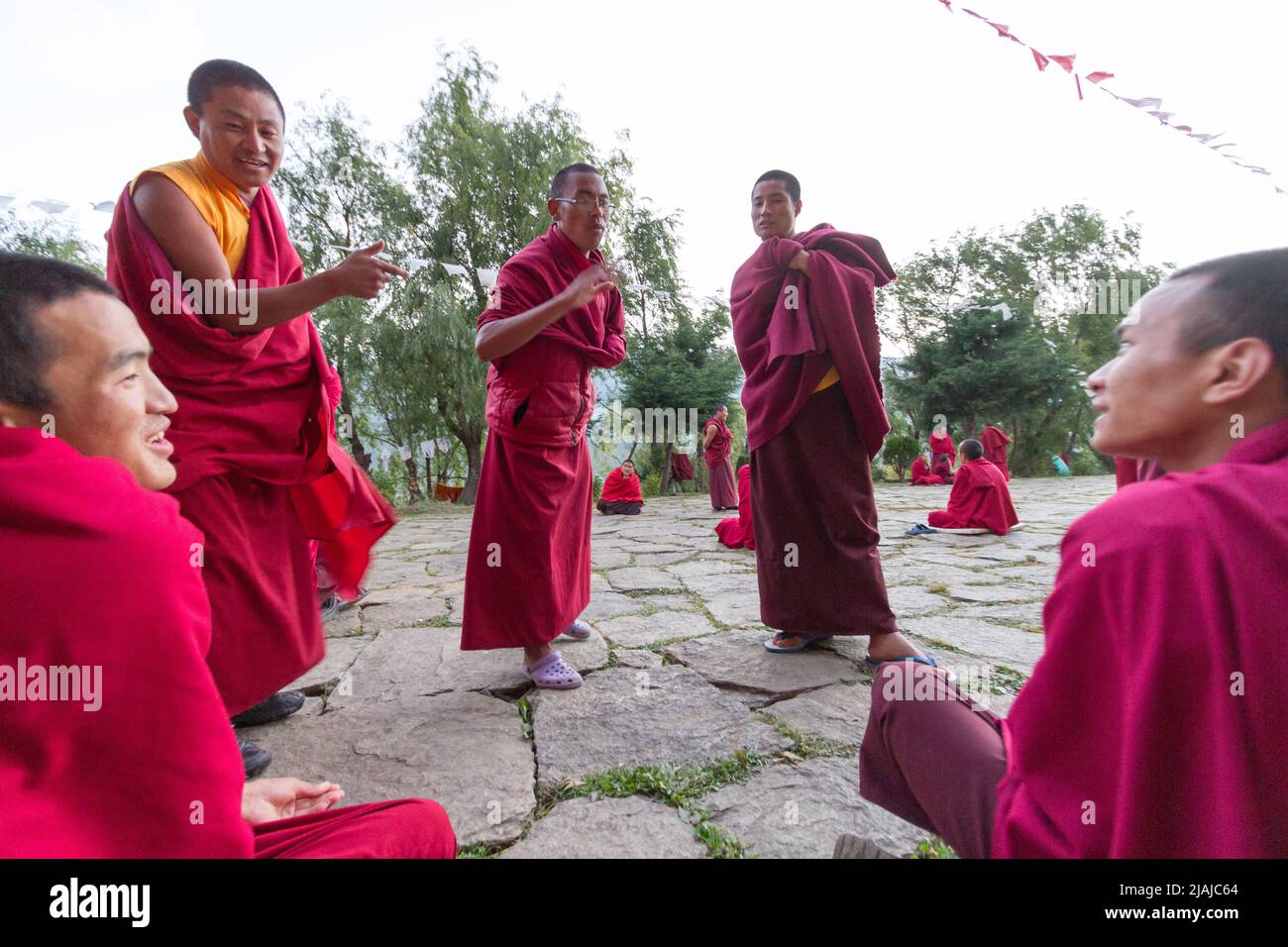 Bhutanese Buddhist monks engage in philosophical debates in the courtyard of a monastery in Bumthang, Bhutan Stock Photo