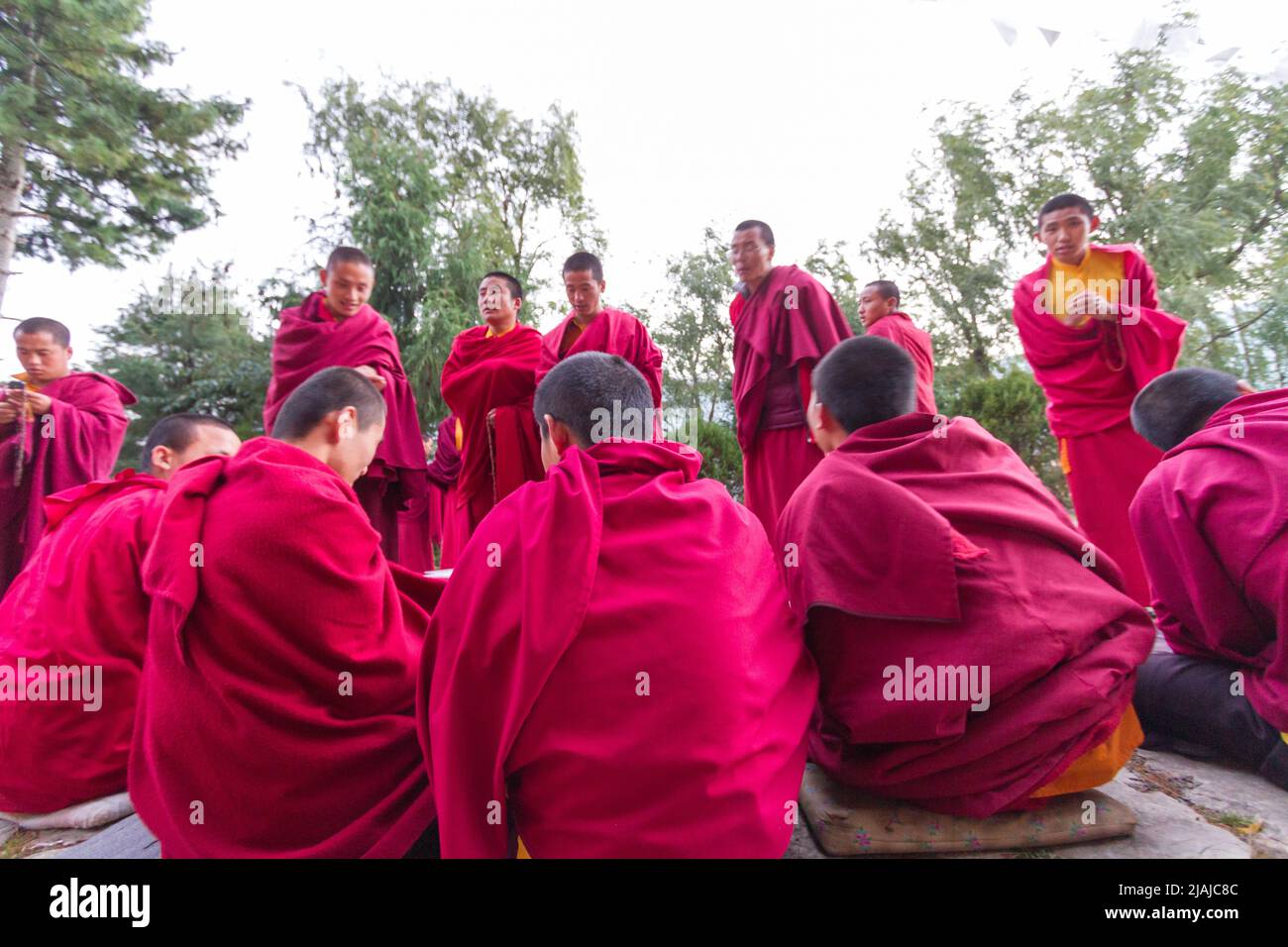 Bhutanese Buddhist monks engage in philosophical debates in the courtyard of a monastery in Bumthang, Bhutan Stock Photo