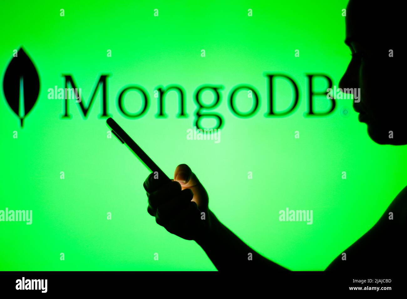 In this photo illustration, the MongoDB logo is seen in the background ...