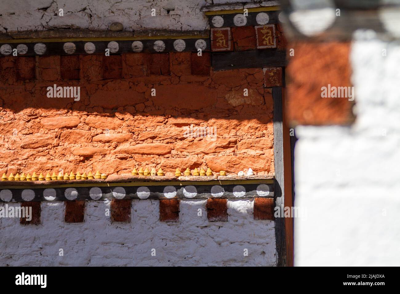 White and orange walls of a Buddhist monastery in Bhutan - Unnamed Road, , Bumthang, Bhutan (BT) Stock Photo