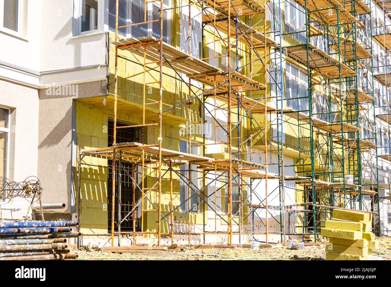 scaffolding for facade decoration is installed near the walls of a multi-storey residential building, selective focus Stock Photo