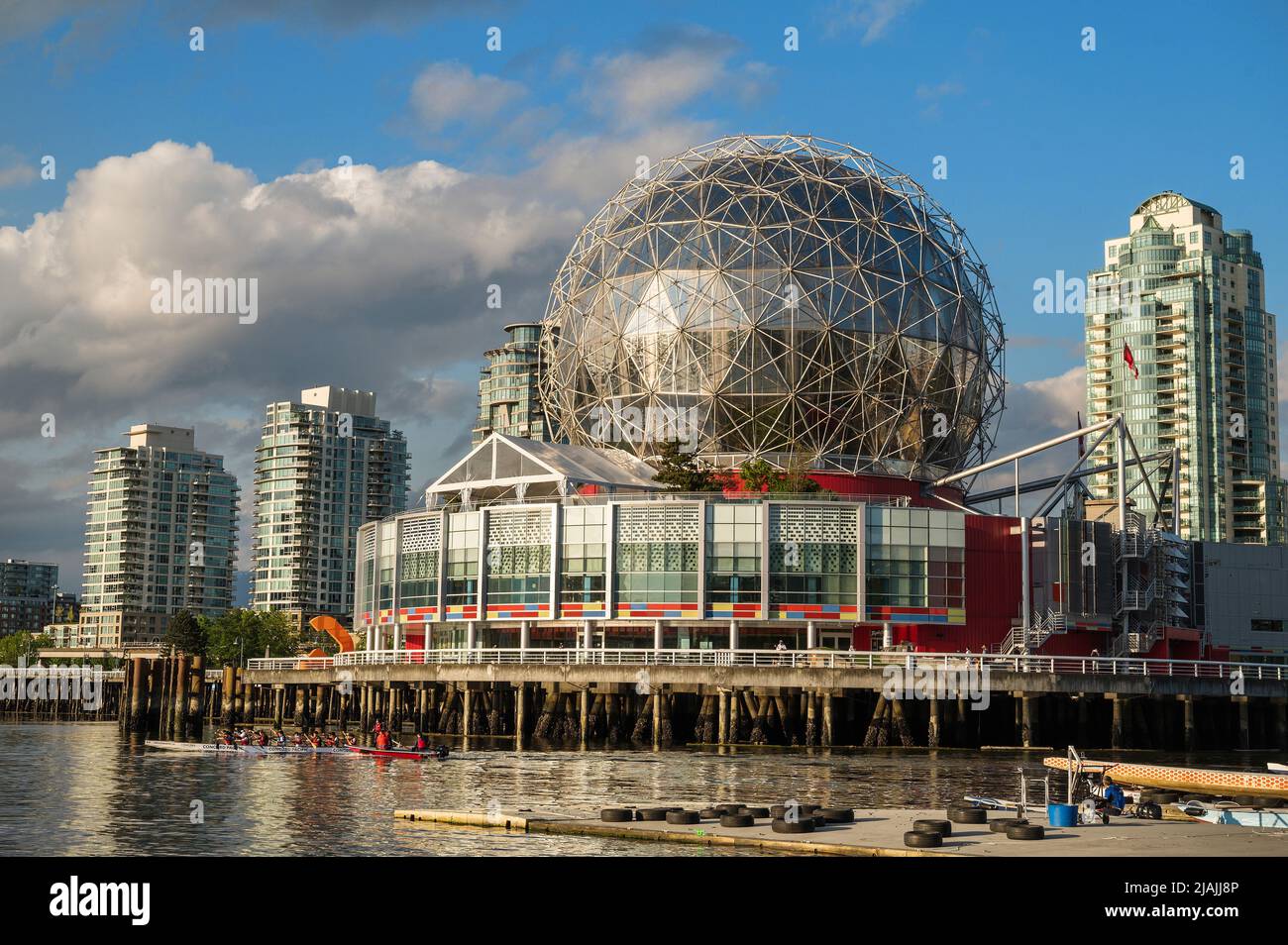 Vancouver Science World at the end of False Creek with yachts moored in the harbour with Dragon Boats training in the harbour. Stock Photo