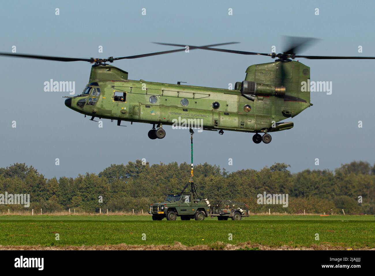 A Royal Netherlands Air Force CH-47 Chinook prepares to lift its sling load during a military exercise. Stock Photo