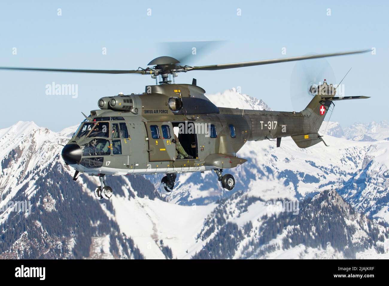 A Swiss Air Force AS332 Super Puma tactical transport helicopter flying in  the Swiss Alps Stock Photo - Alamy