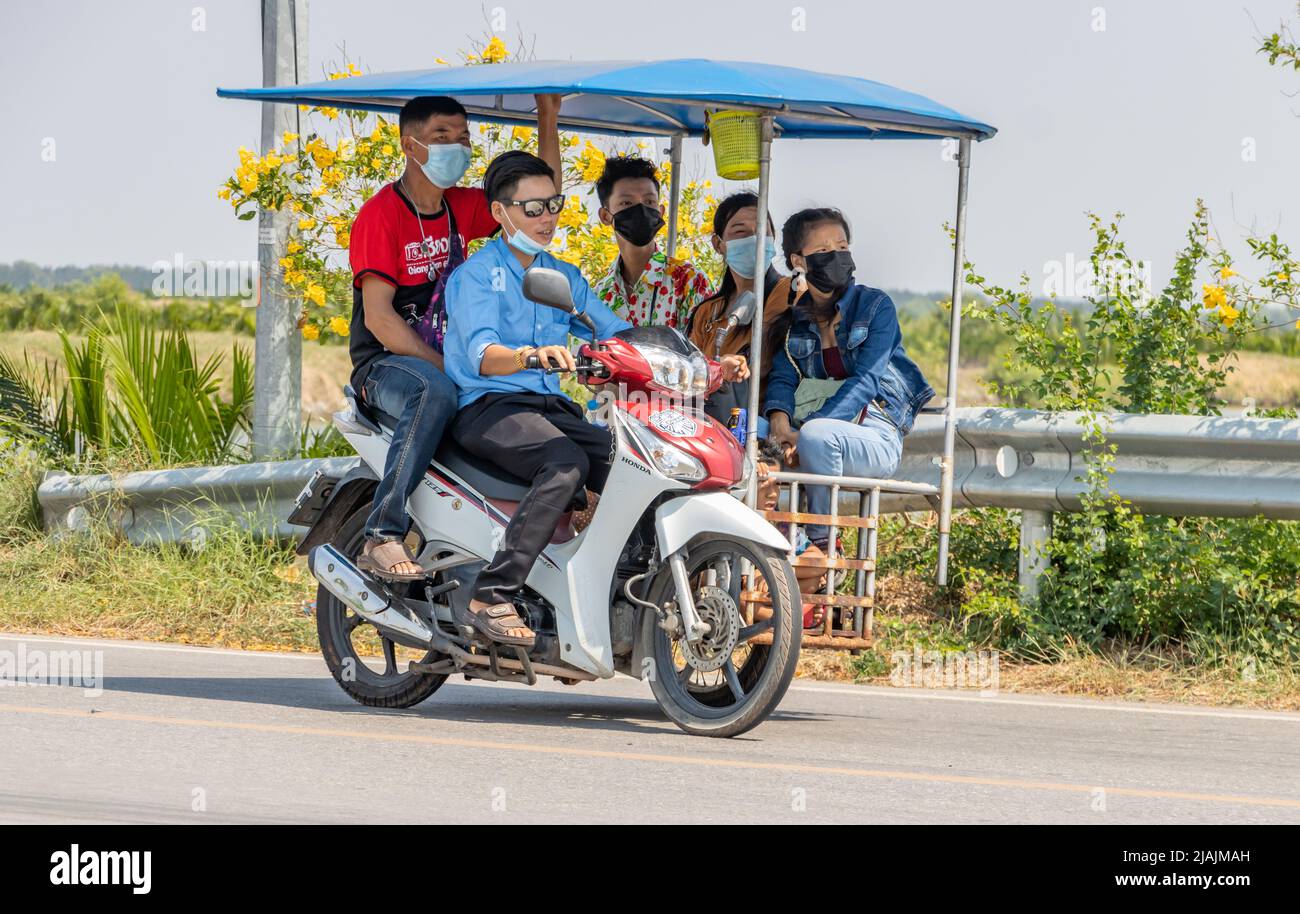 SAMUT PRAKAN, THAILAND, APR 14 2022, Group of people riding a tricycle - motorbike with cart, Thailand. Stock Photo