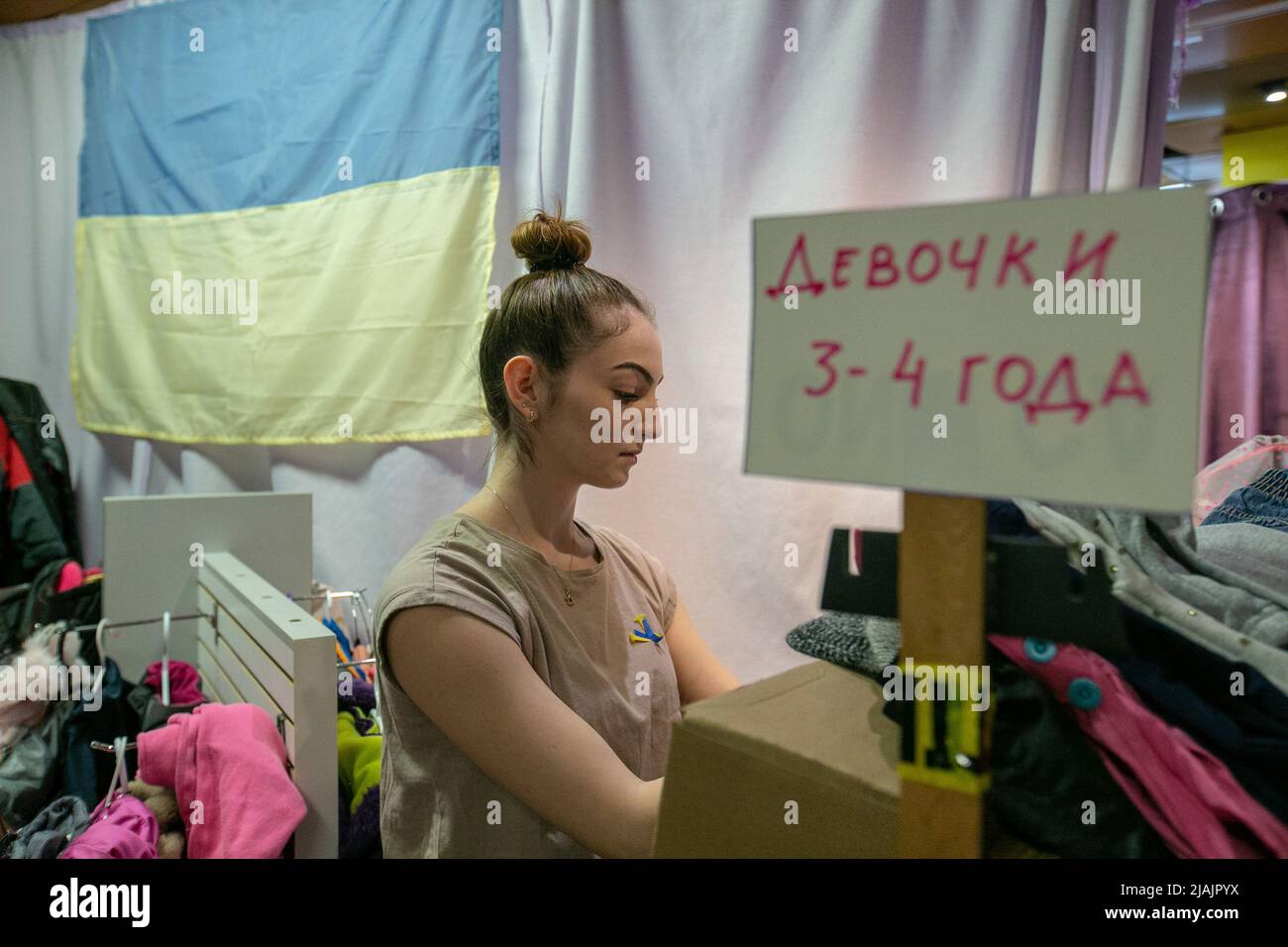 A volunteer helps organizing donations, divided and marked with