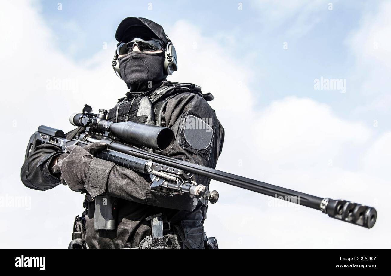 Police tactical group sniper in black uniform and mask, holding sniper ...