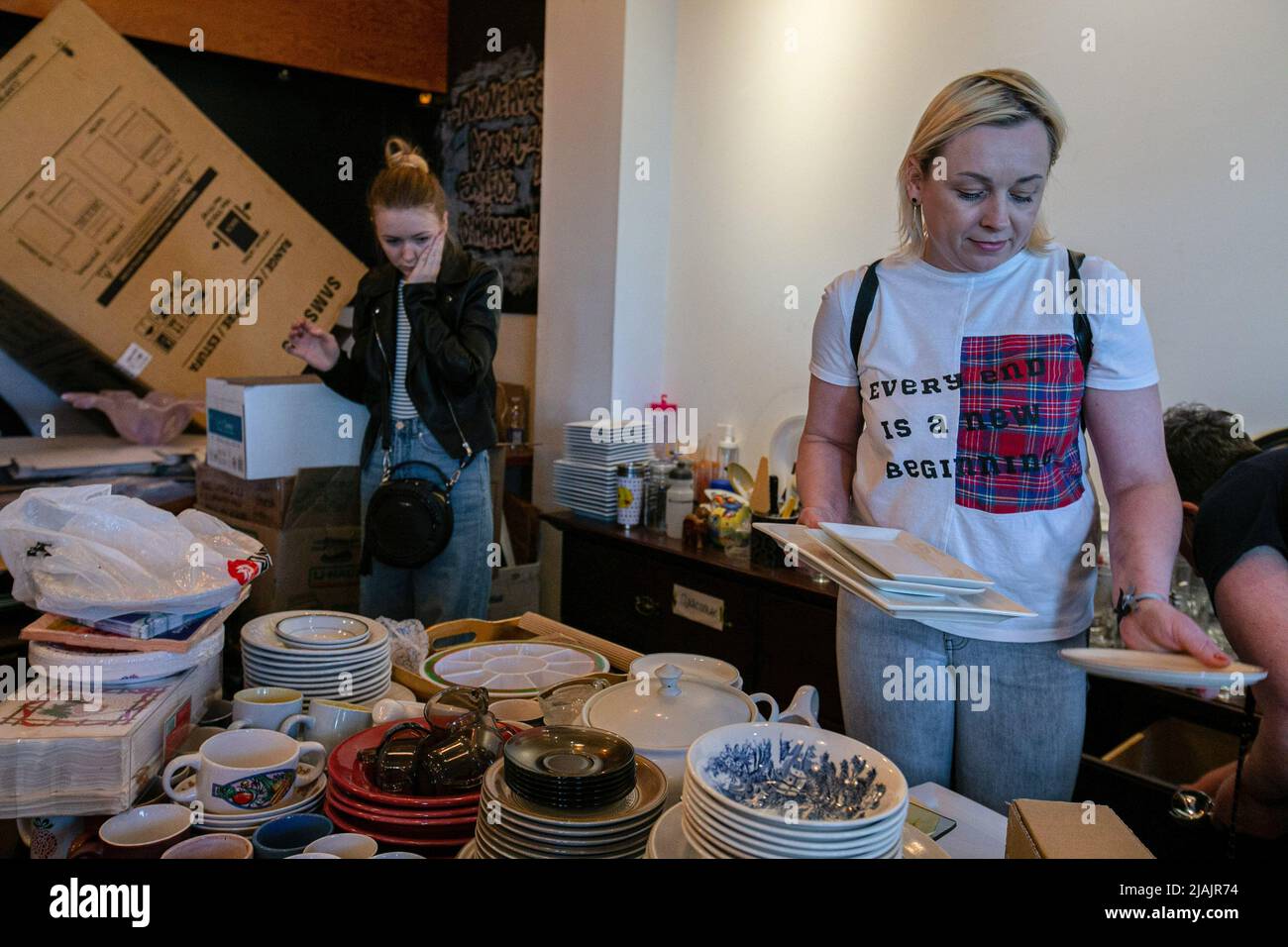 Ukrainian refugees go through the piles of donations. As the war in