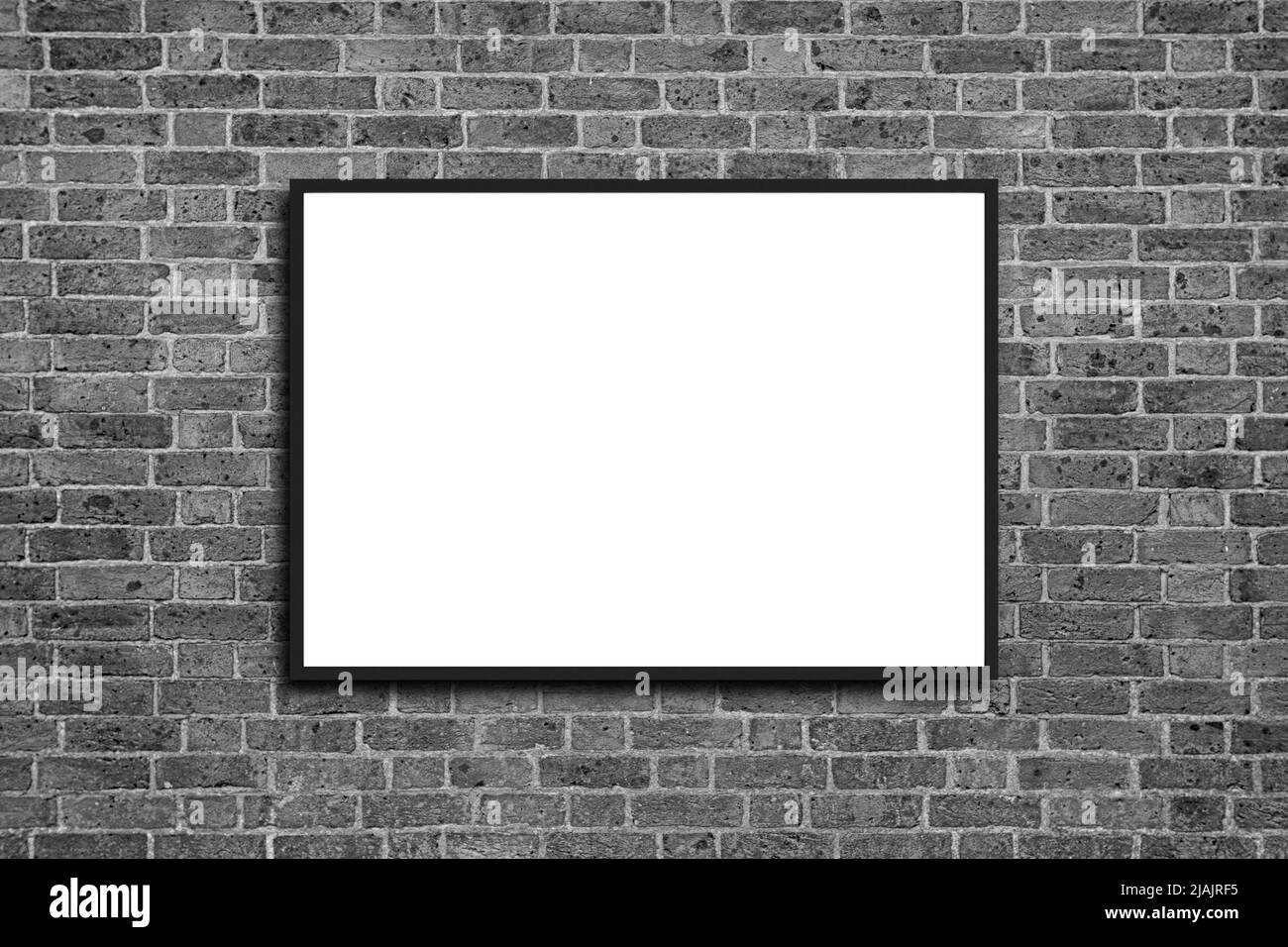 Empty frame. Blank black mounted portrait frame on white brick wall Stock Photo