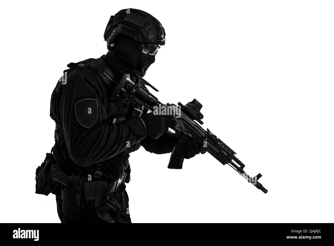 Studio portrait of police special reaction team member black uniform and helmet, armed with assault rifle. Stock Photo