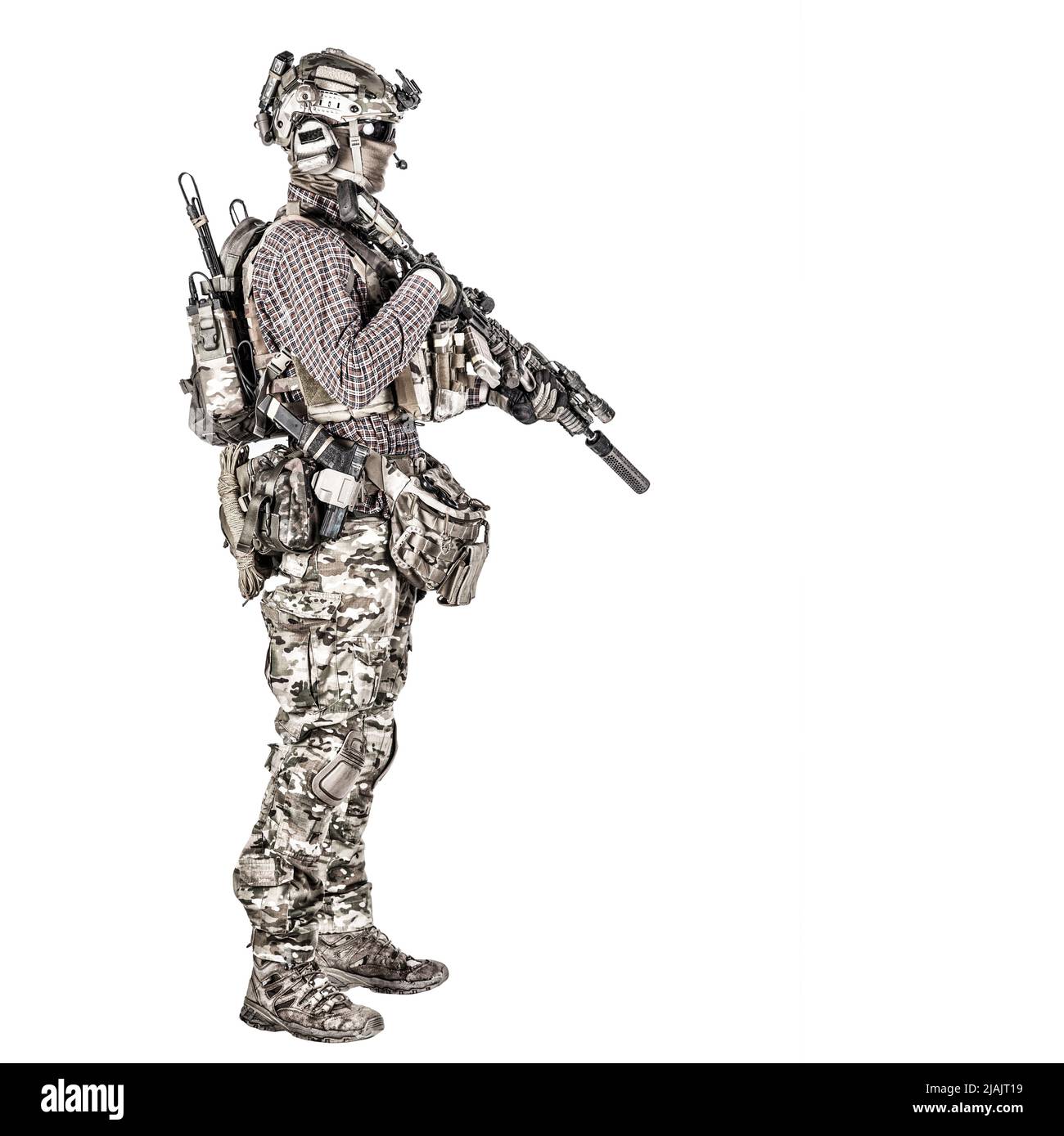 Full length portrait of airsoft player in camoflauge uniform and radio headset, with service rifle. Stock Photo