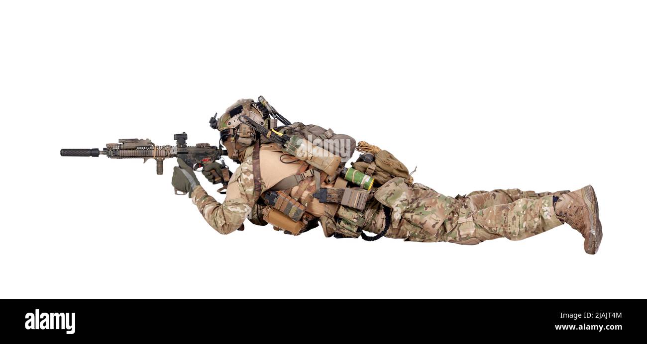 Soldier shooting assault rifle while lying on ground, isolated on white background. Stock Photo