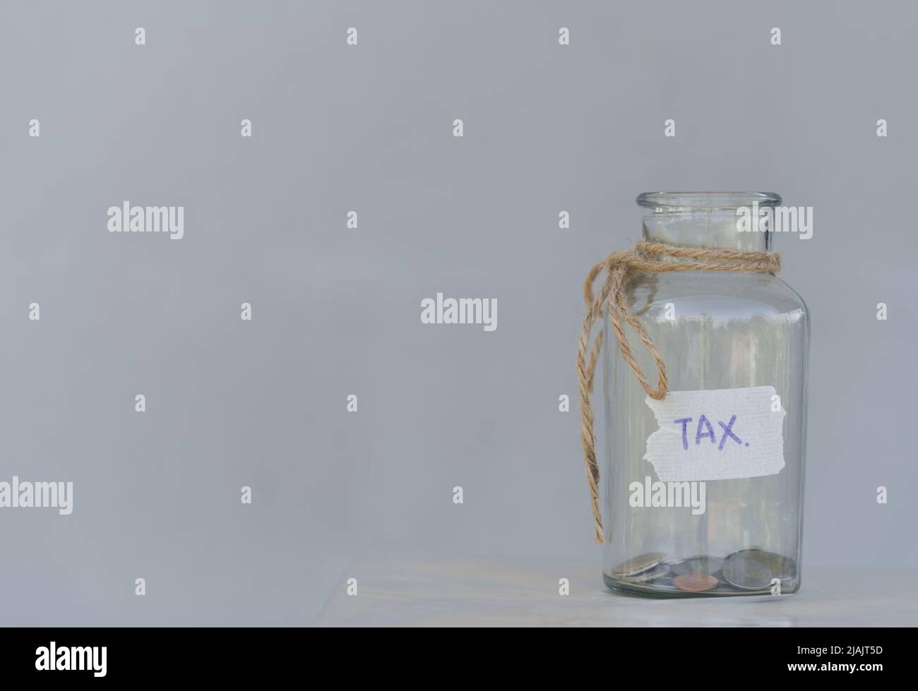 coin in a glass jar with coins on white background. separated into concepts Having a collection of money to keep in reserve for emergencies and paying Stock Photo