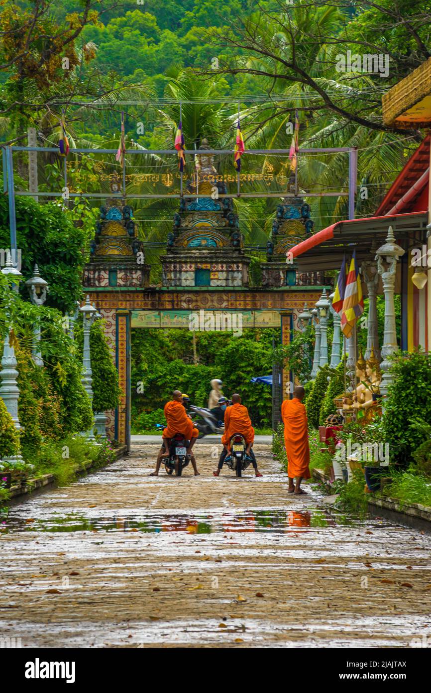 An Giang Province, Vietnam - May 01, 2022 : Khmer monks riding scooter on rural road in Mekong Delta, An Giang, Vietnam. Khmer pagodas and villages su Stock Photo