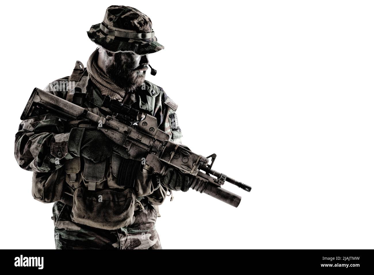 Commando soldier in camouflage uniform and boonie hat, armed with service rifle, studio shot on white background. Stock Photo