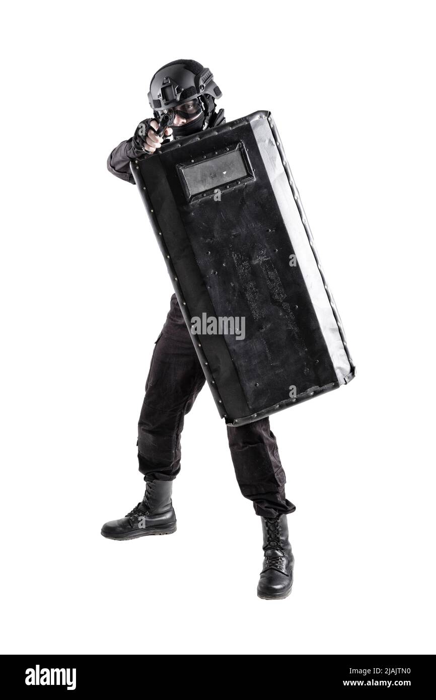 SWAT team fighter protecting himself behind ballistic shield while aiming pistol. Stock Photo