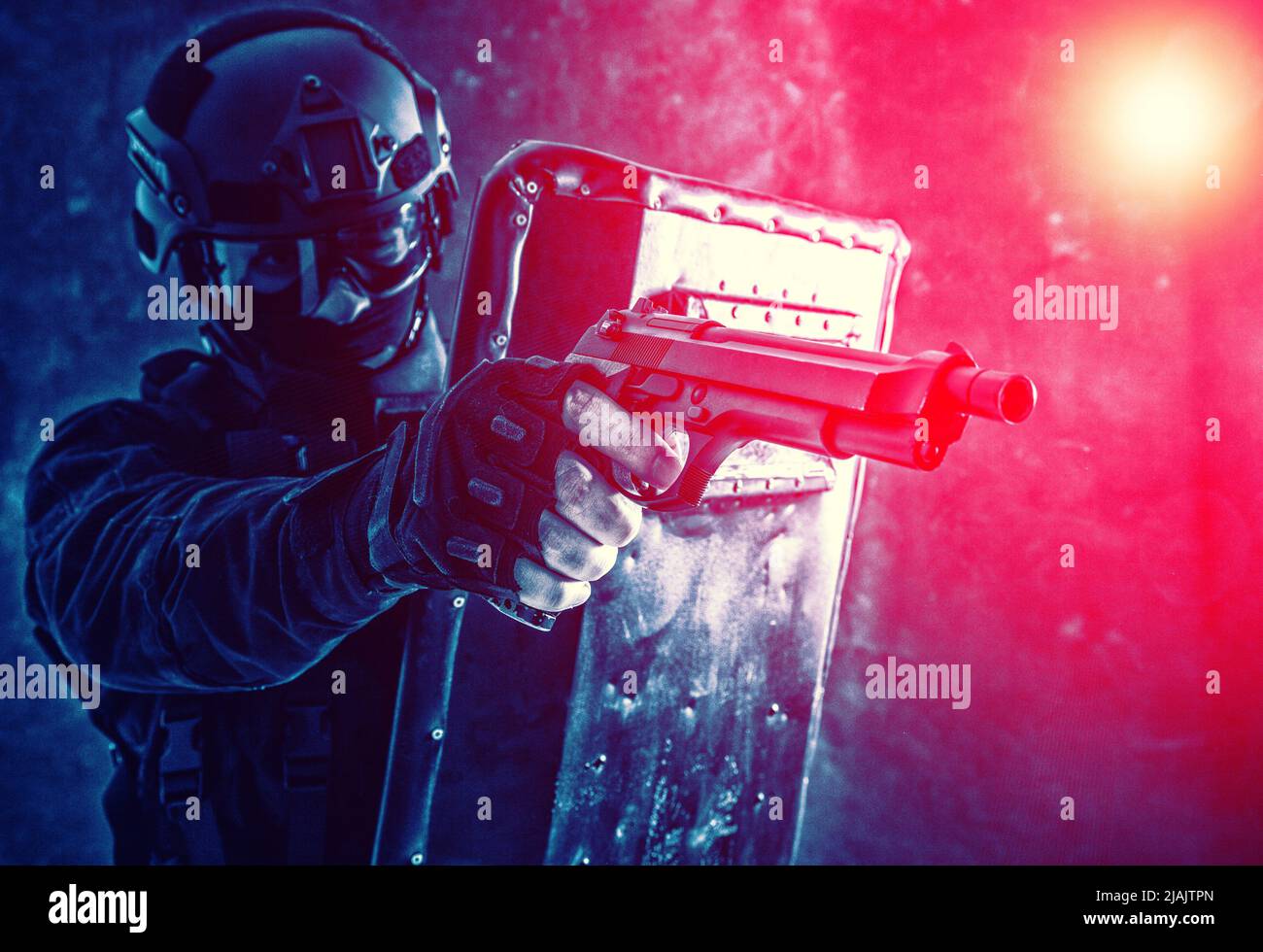 SWAT team fighter aiming pistol from behind ballistic shiield during a firefight. Stock Photo