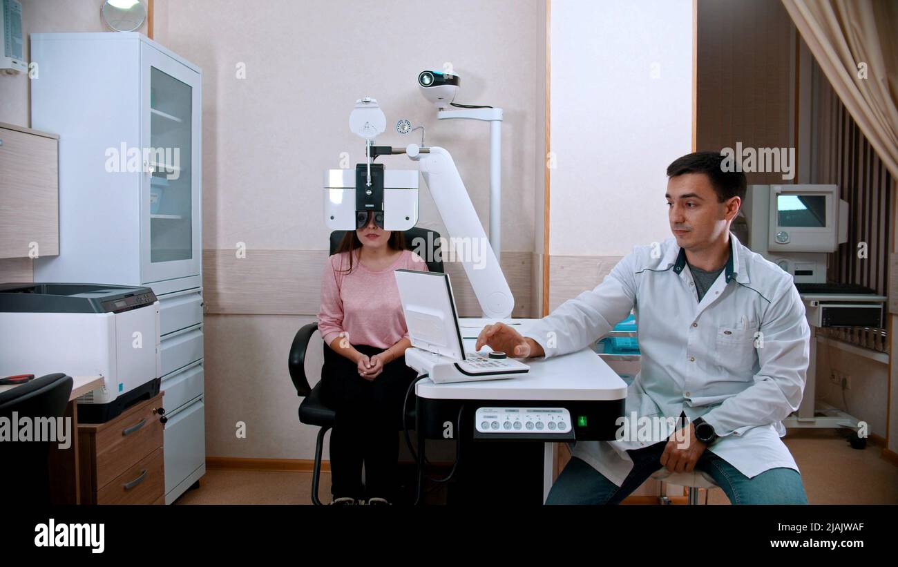 Ophthalmology treatment - young woman checking her visual acuity with ...