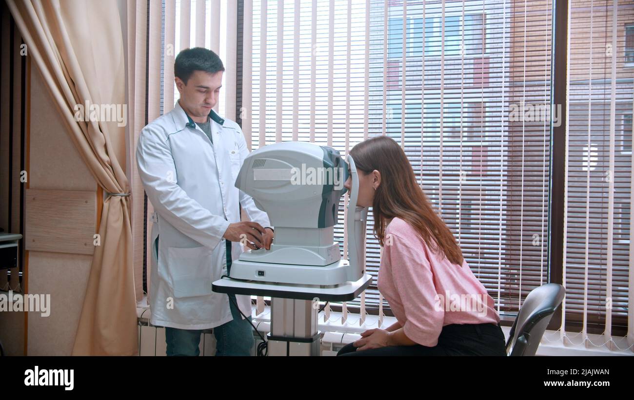 Ophthalmology treatment - young woman checking her visual acuity with a ...
