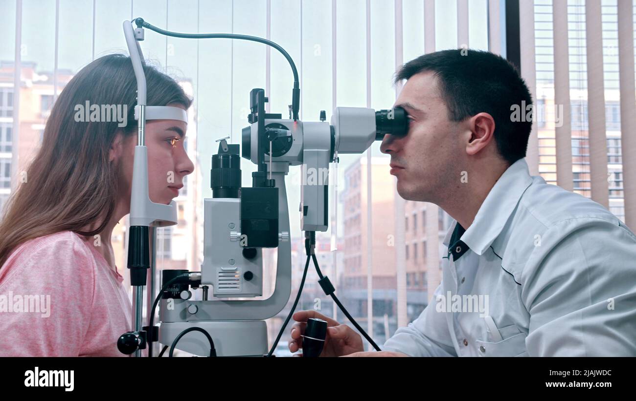 Ophthalmology - young pretty woman checking her visual acuity with a ...