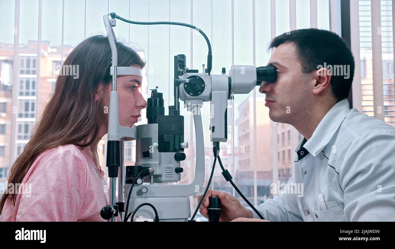Ophthalmology - young woman checking her visual acuity with a special ...