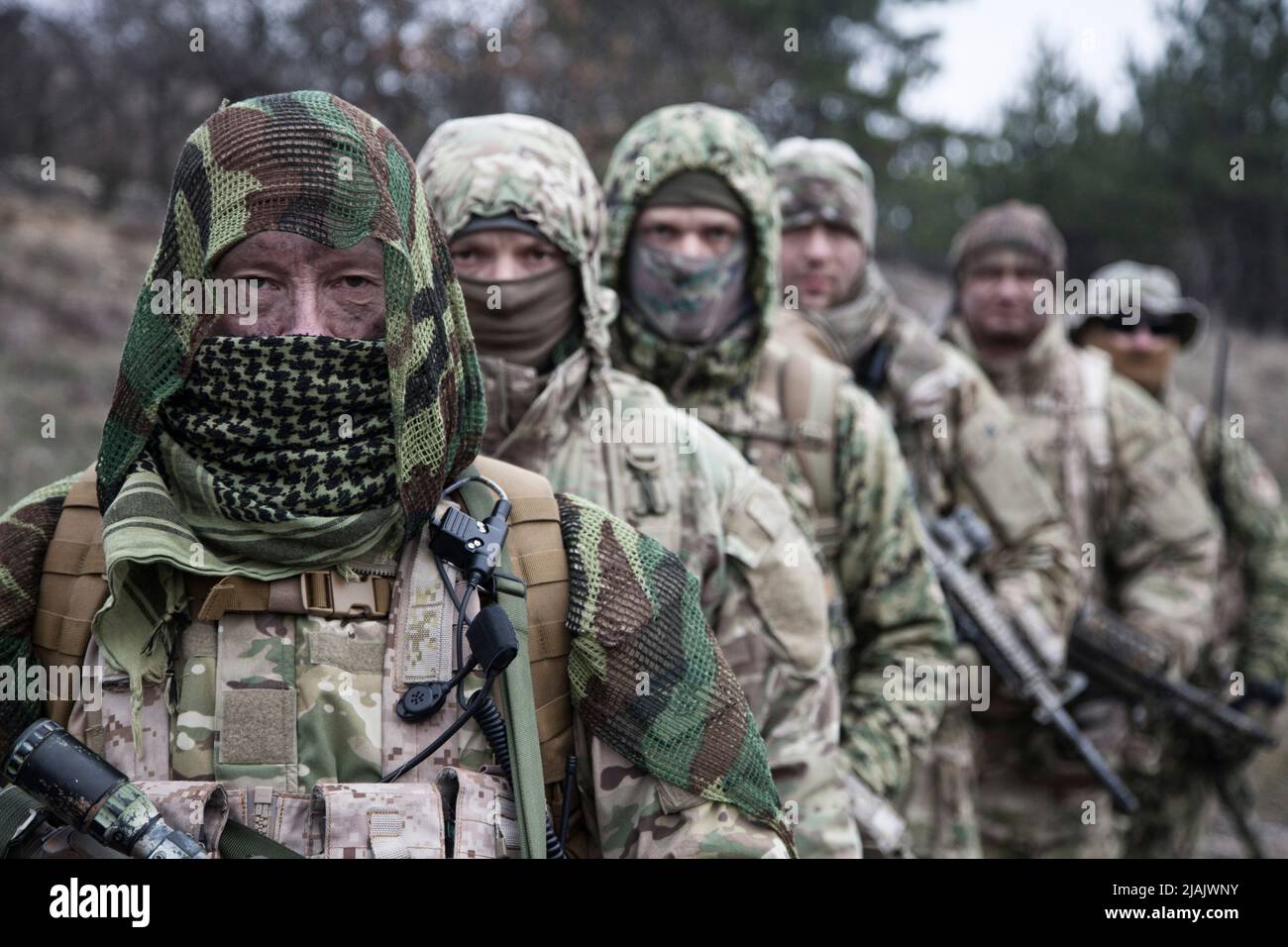 Group of skilled commandos wearing camouflage uniforms and masks ...