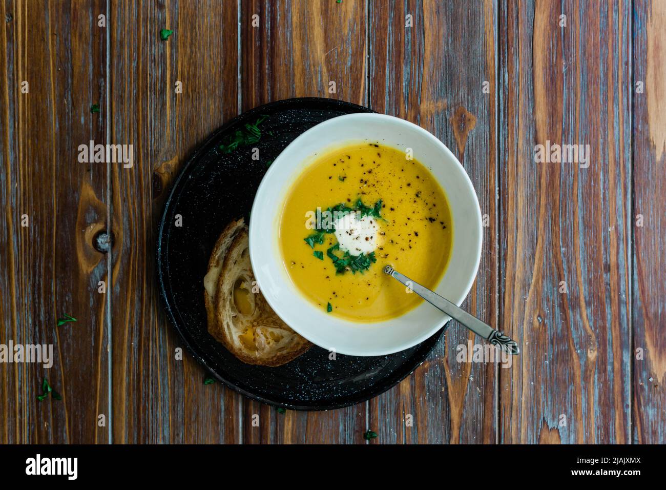 Butternut squash soup on a wood table with linen napkins and a cozy