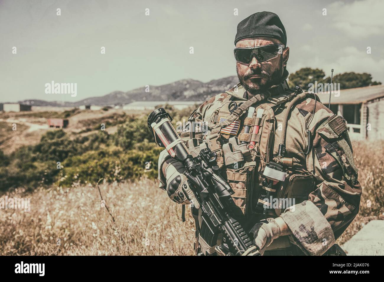 Half-length portrait of an armed Navy SEALs fighter wearing ballistic goggles while standing outdoors. Stock Photo