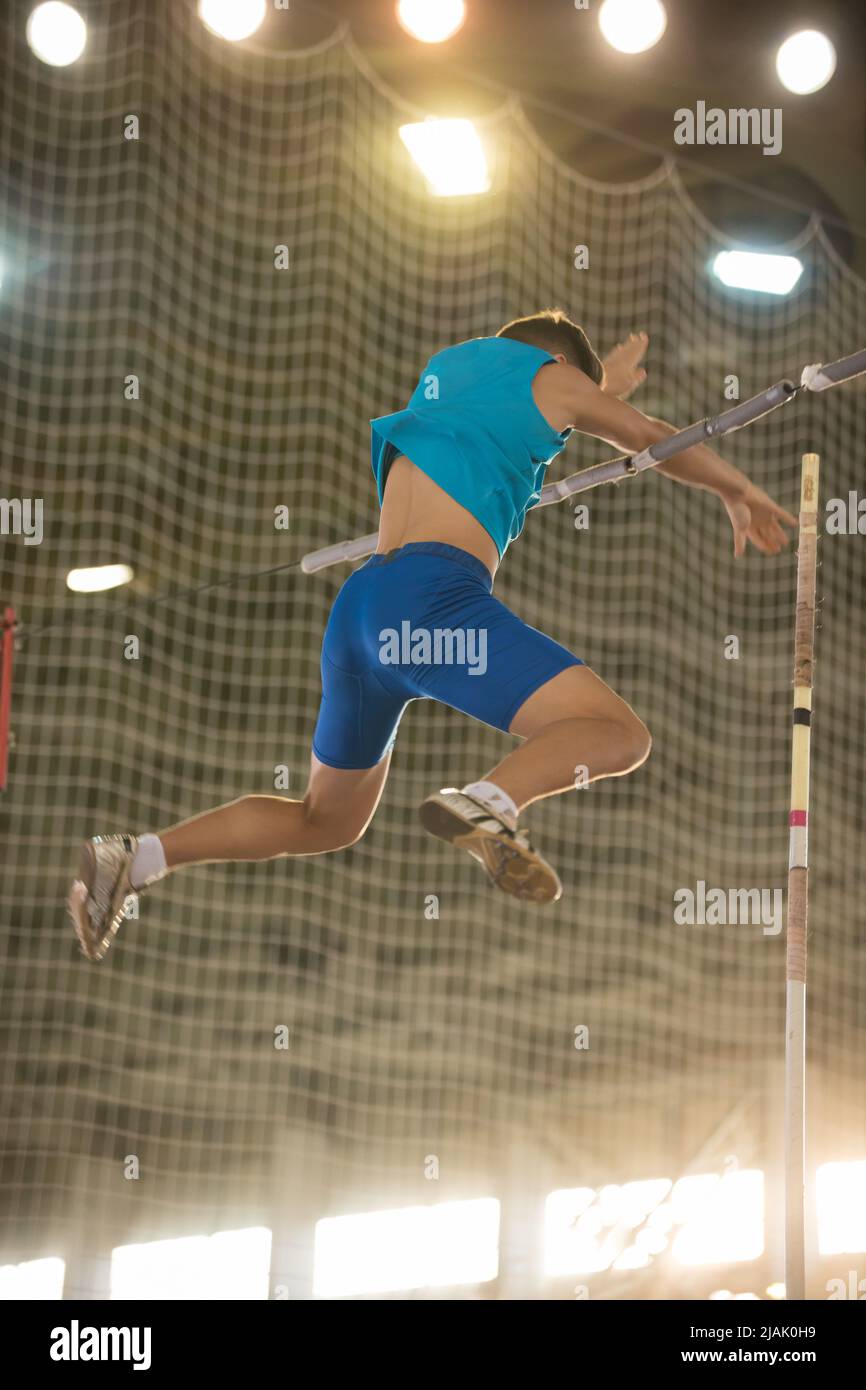 Pole vault training in the sports stadium young fit man falling down