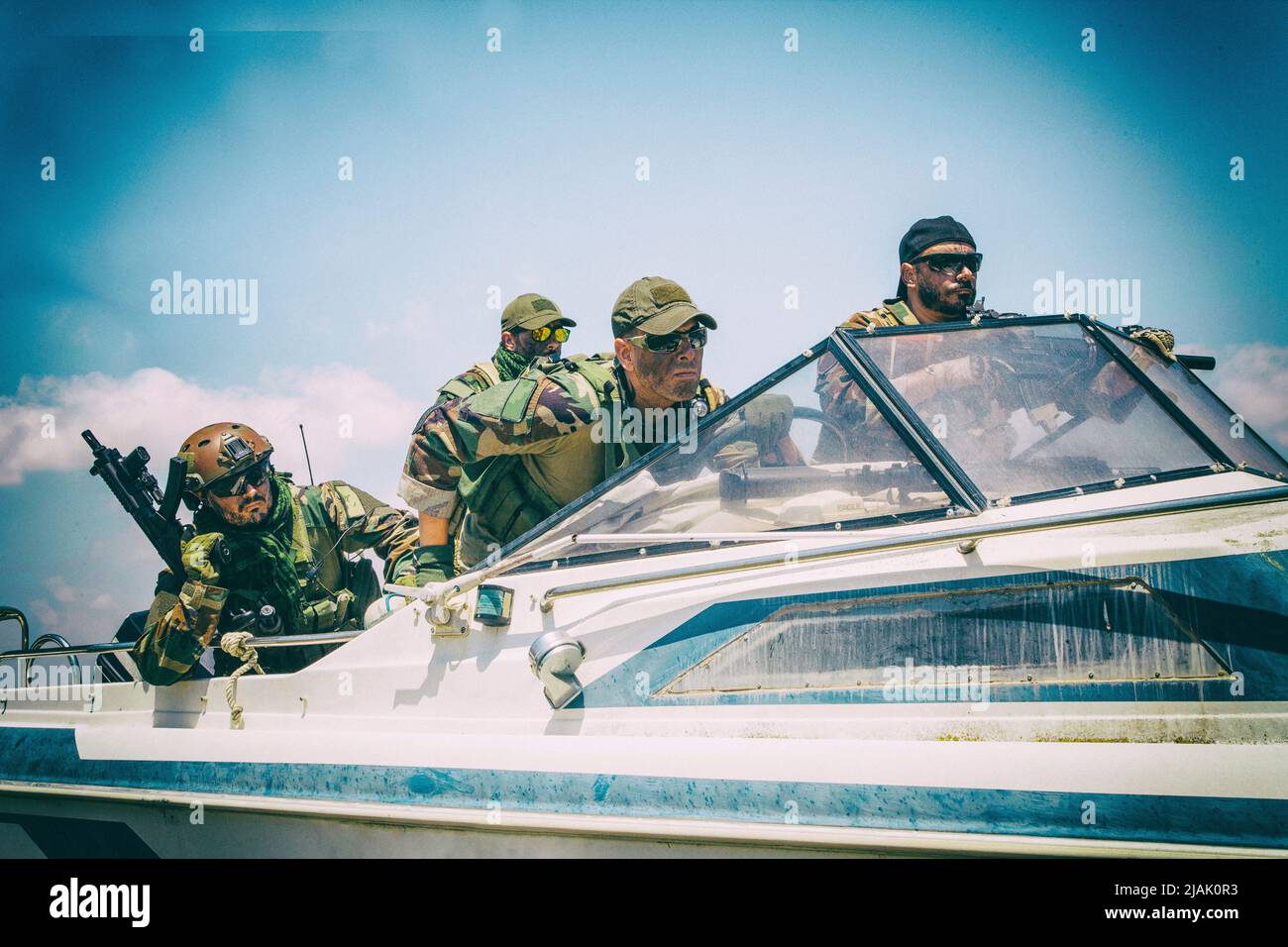 Armed Navy SEALs chasing their enemy on a boat. Stock Photo