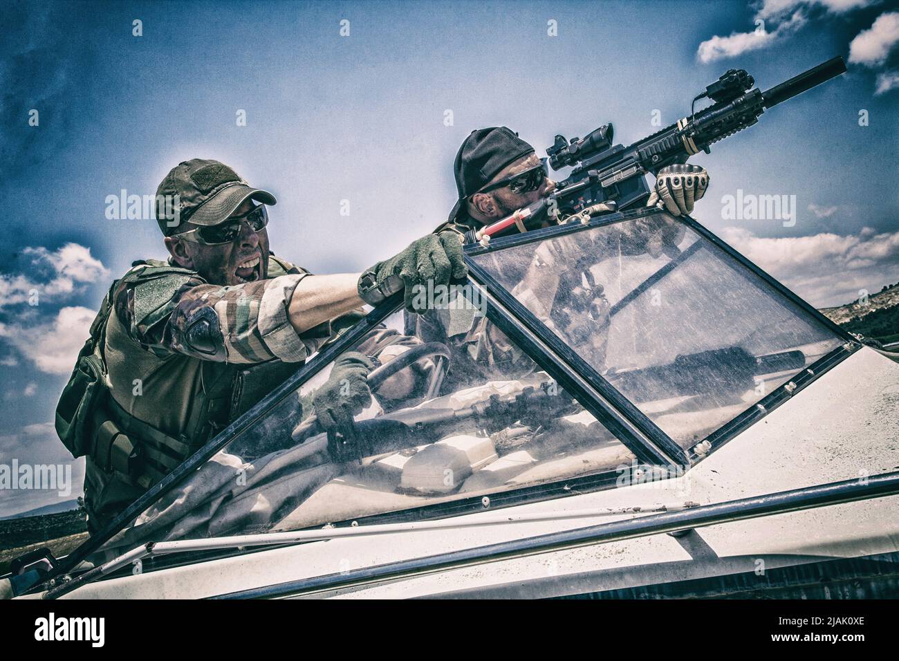 Armed Navy SEALs attacking their enemy while on a boat. Stock Photo