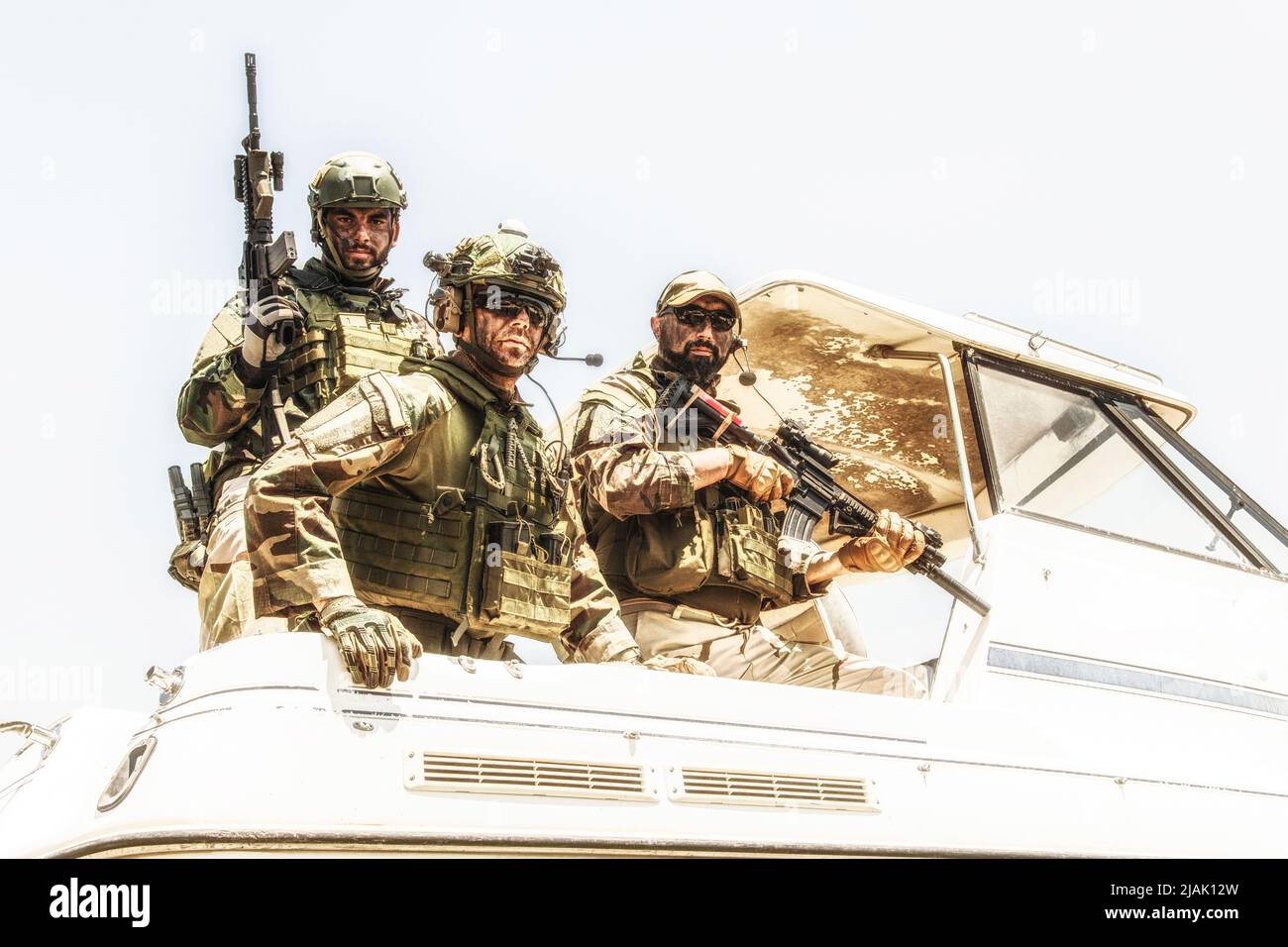 Navy SEALs standing together on stern of speed boat. Stock Photo