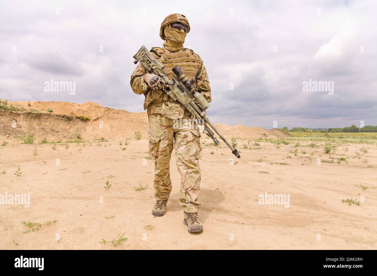 Fully equipped and armed soldier with rifle in the desert. Stock Photo
