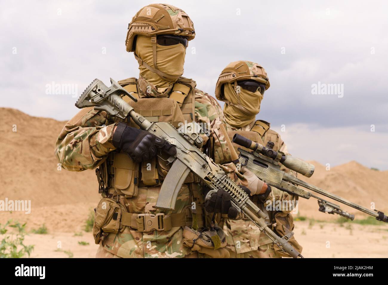 Two equipped and armed special forces soldiers with rifles in the desert. Stock Photo