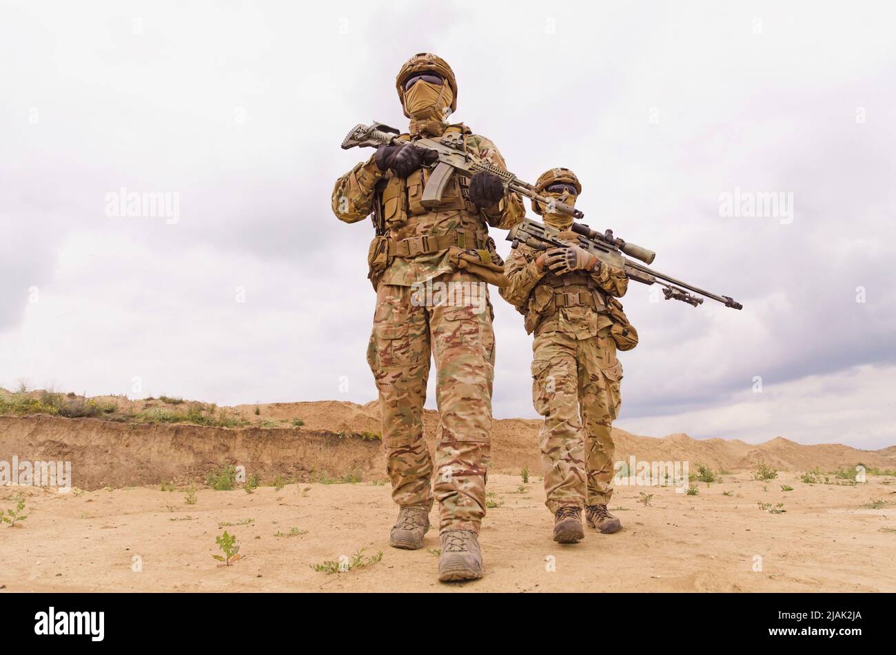 Equipped and armed special forces soldiers with rifles during military operation in the desert Stock Photo