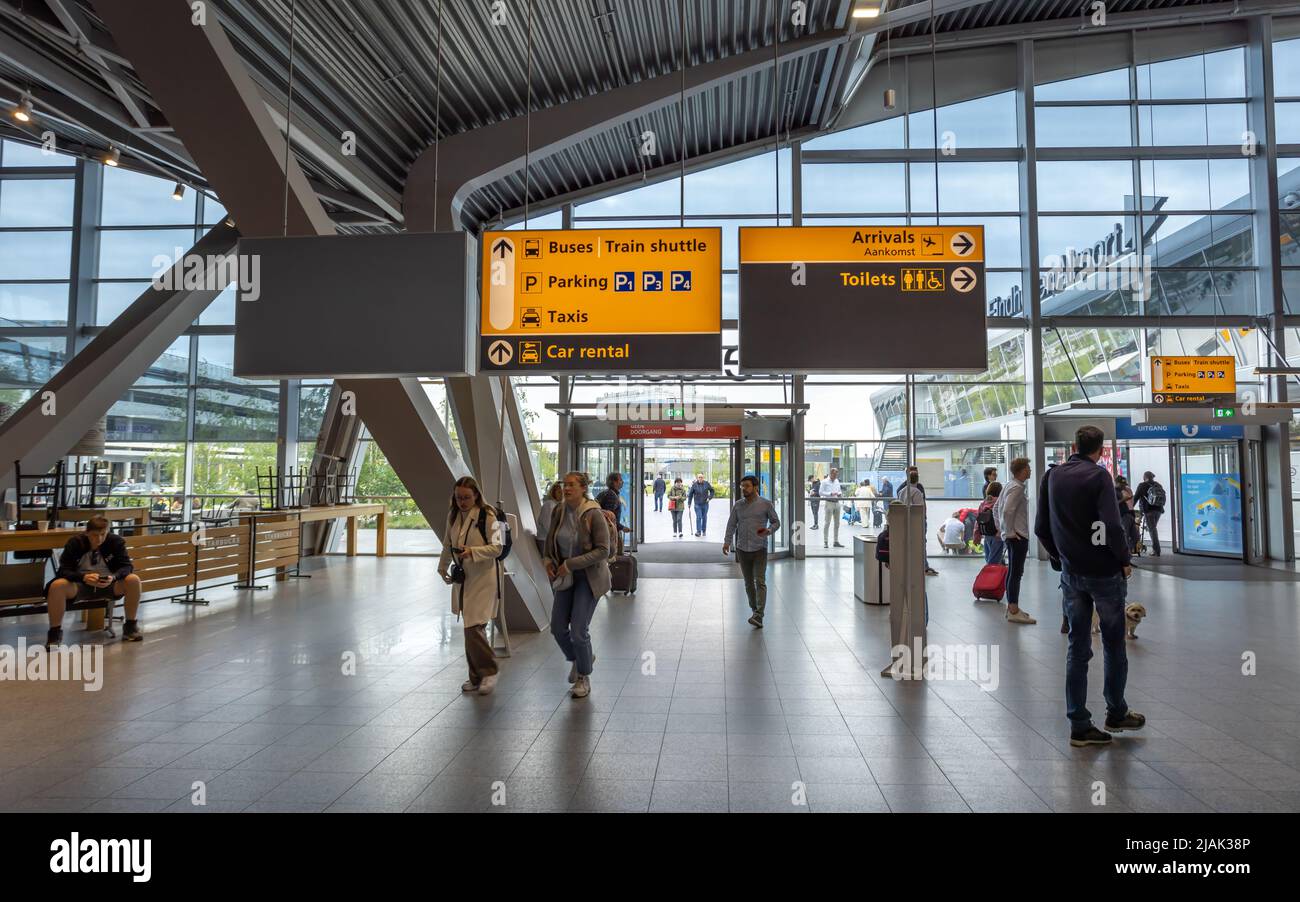 People at Eindhoven airport walking under signage in the airport terminal building Stock Photo