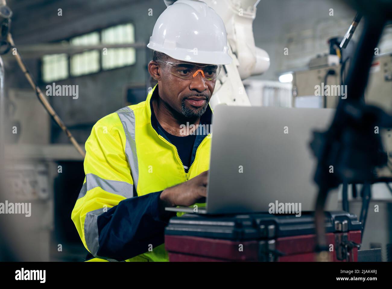 Factory worker working with laptop computer to do adept procedure