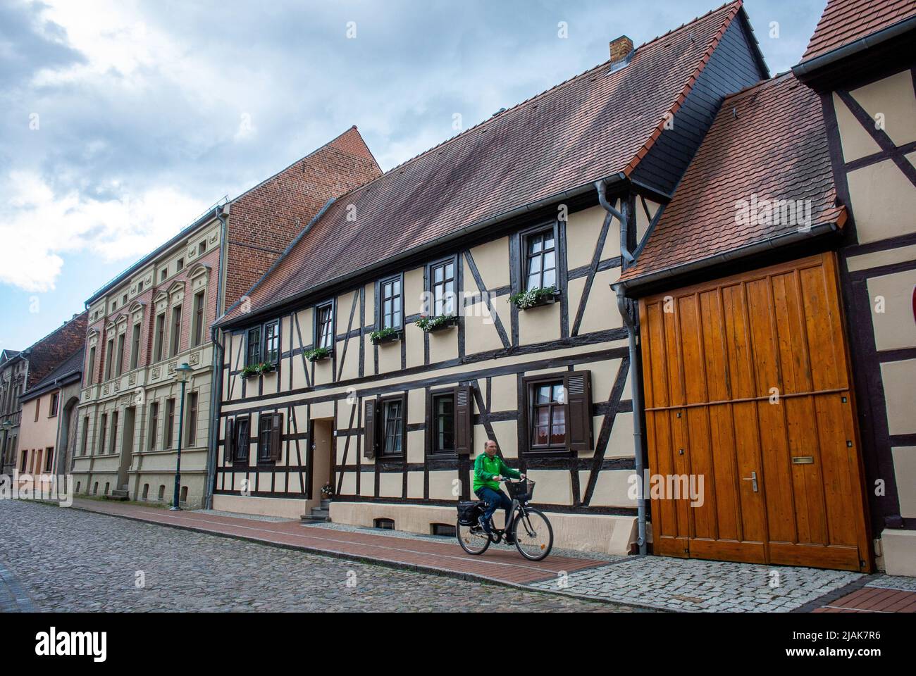 A man cycles through the centre of Wörlitz on a summers day  in Wittenberg, Germany. Stock Photo