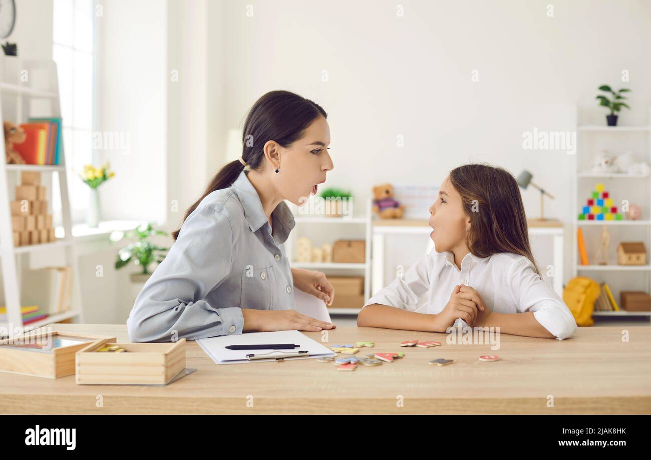 Kid and speech therapist doing articulation exercise to fix some pronunciation problems Stock Photo