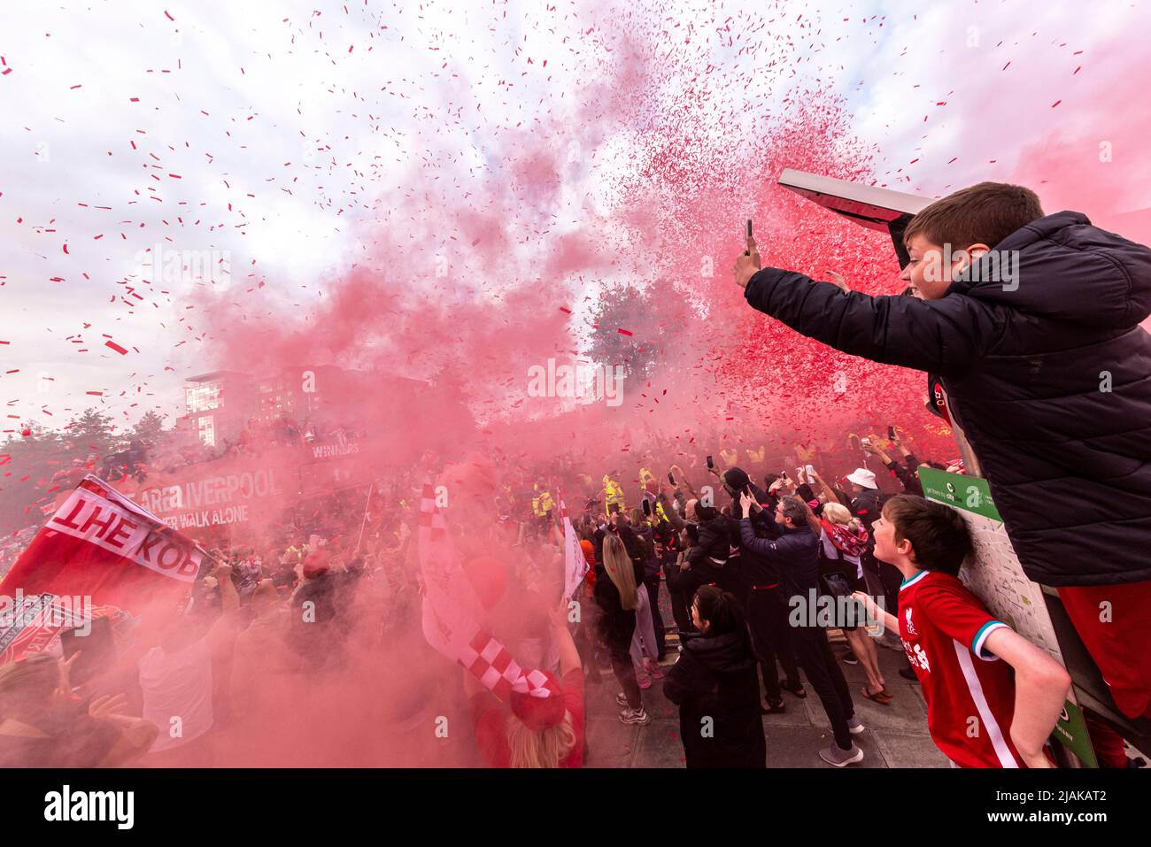 Liverpool Football Club victory parade through the streets of the city celebrating the League Cup and FA Cup trophy wins. Young fans, flare smoke Stock Photo