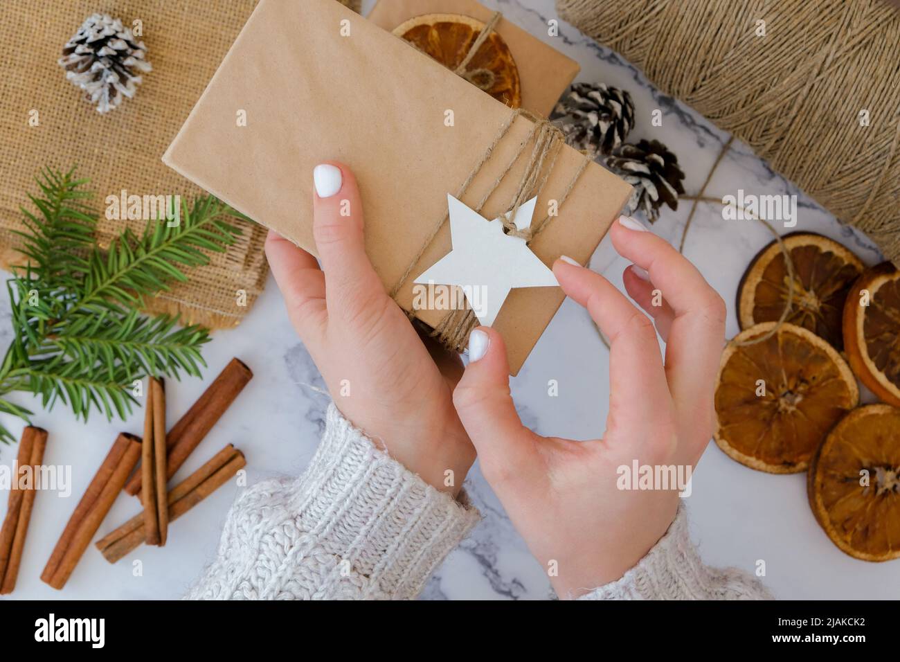 Woman making Box with New Year's gifts, wrapped in craft paper and ...