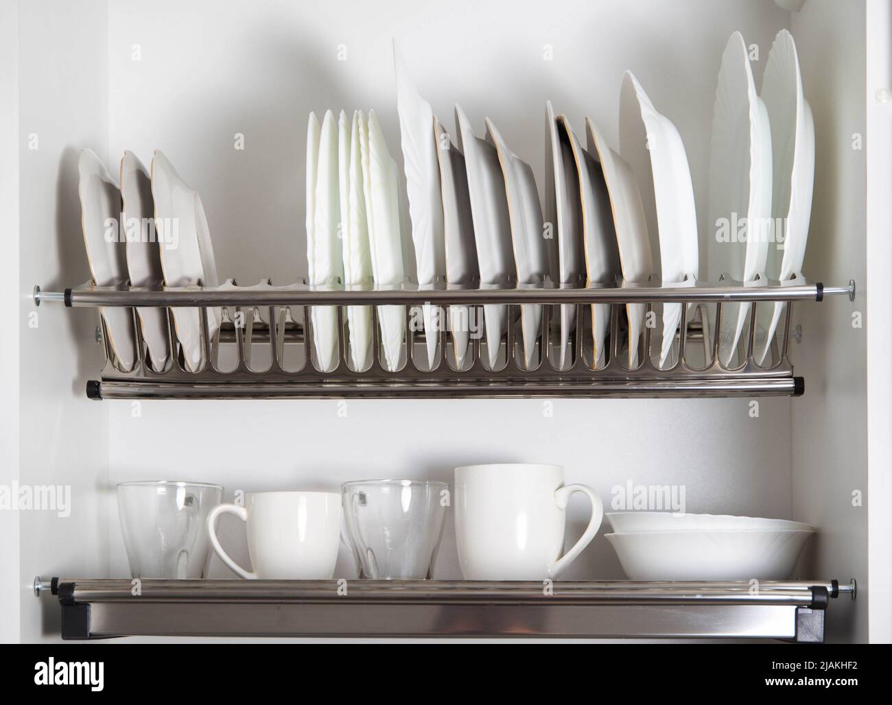 Storage of clean dishes in a separate kitchen section with a lifting mechanism. Modern kitchens, organization Stock Photo