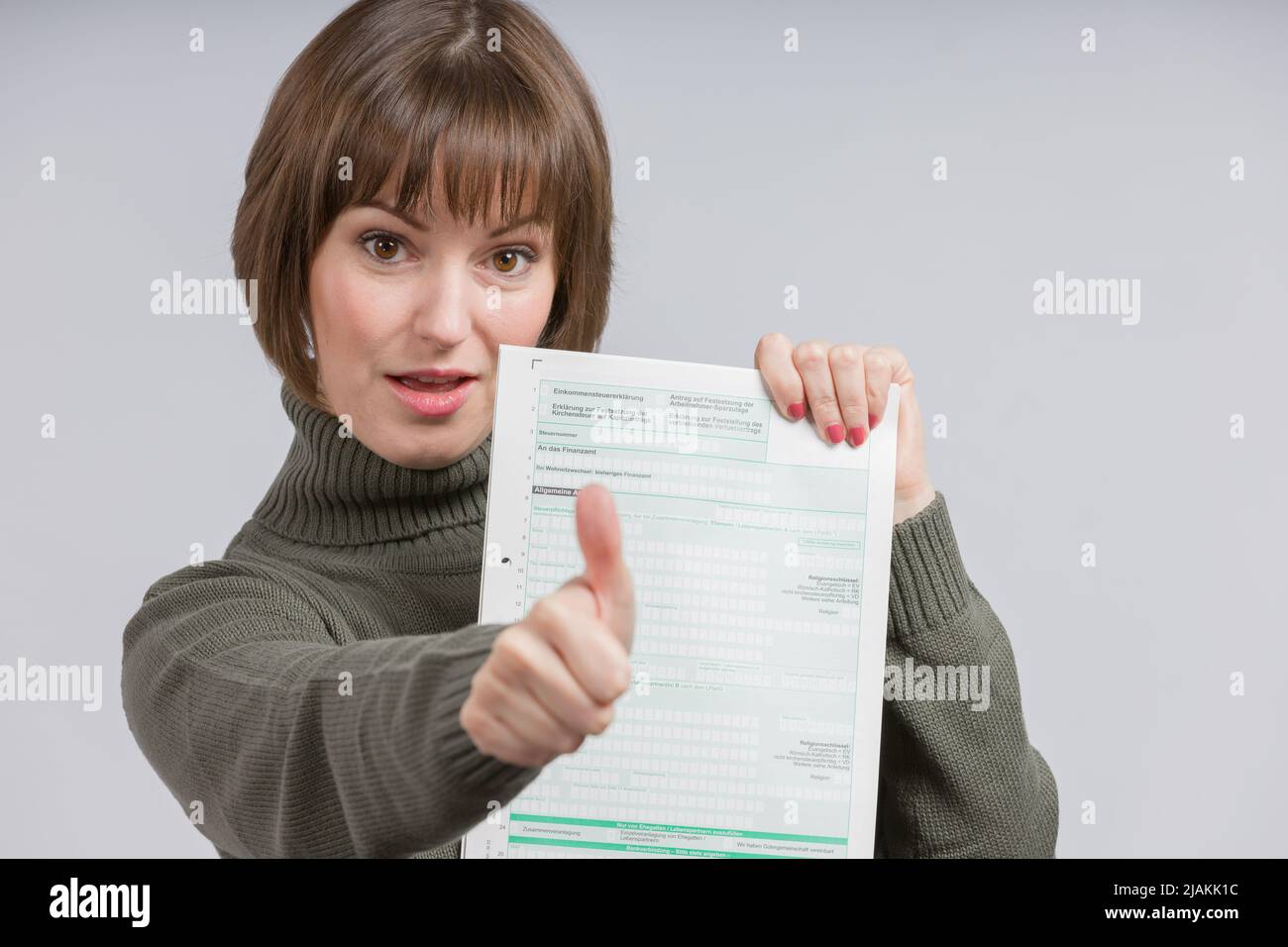 happy woman with a tax form shows thumbs-up Stock Photo - Alamy