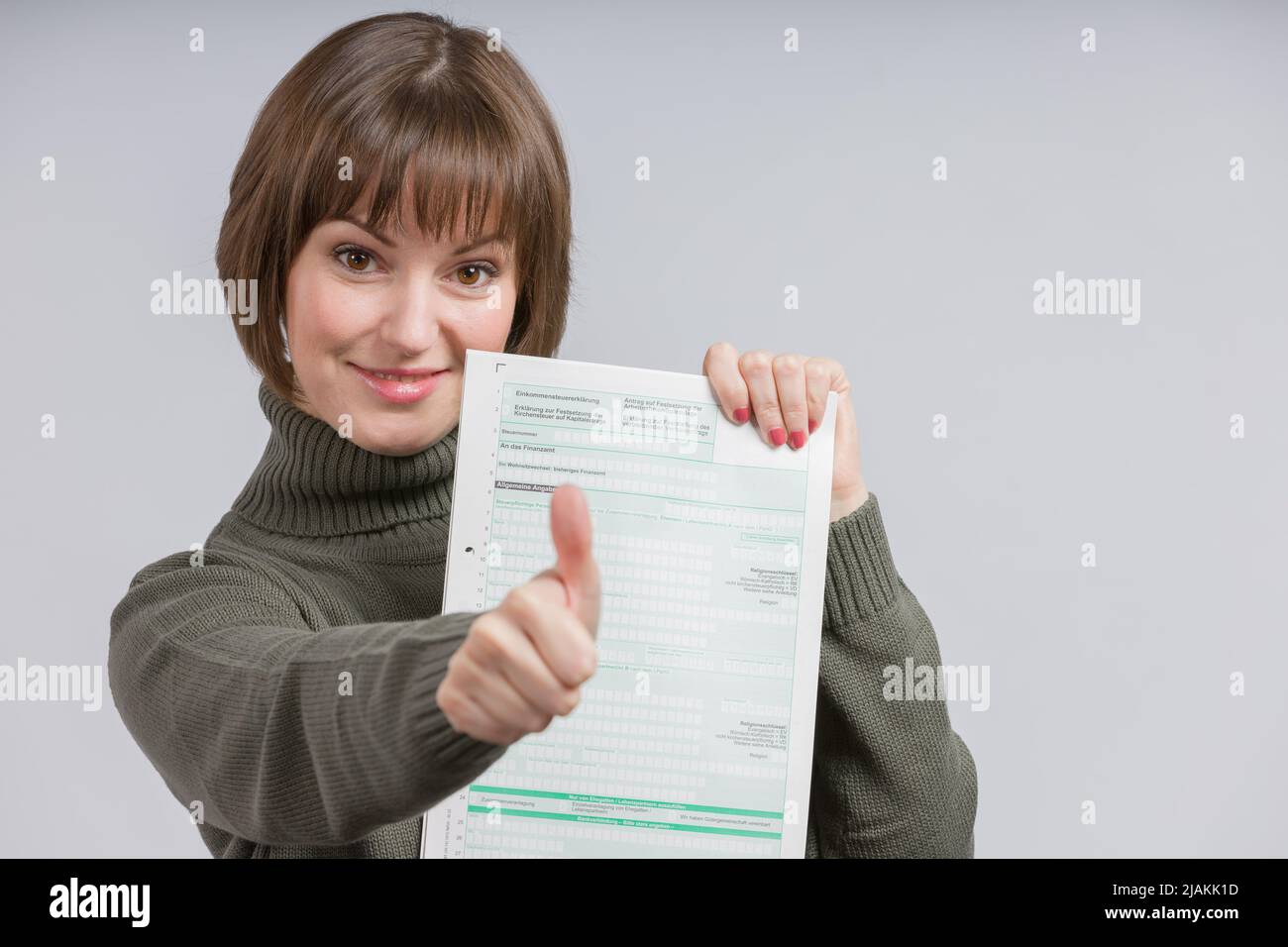happy woman with a tax form shows thumbs-up Stock Photo - Alamy