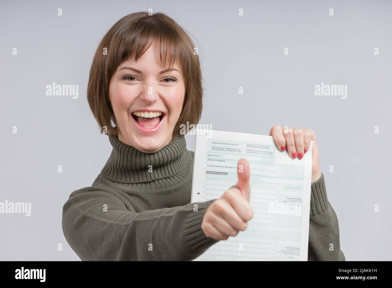 happy woman with a tax form shows thumbs-up Stock Photo - Alamy