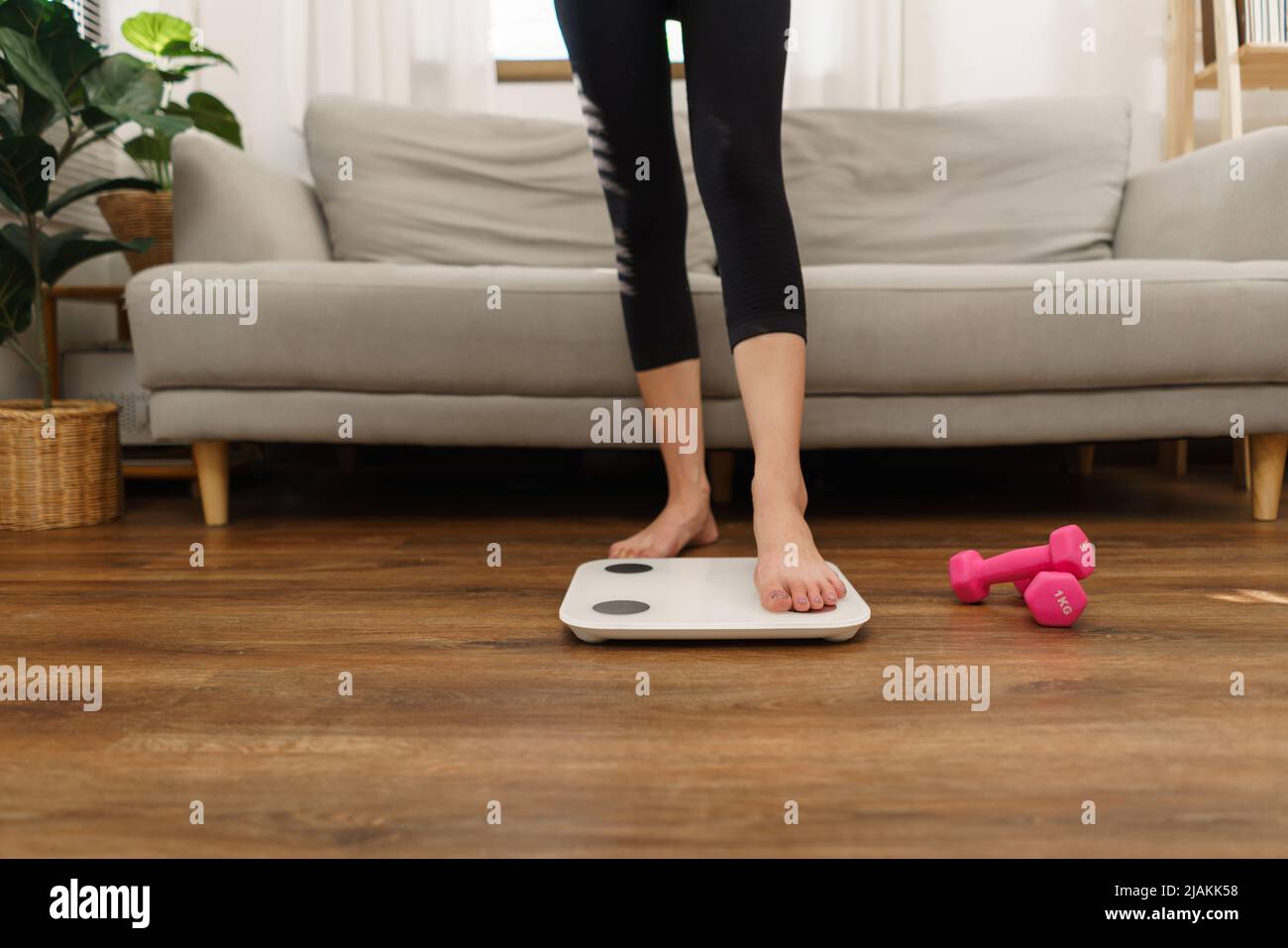 Healthy and weight loss concept, Young Asian woman stepping on weighing ...