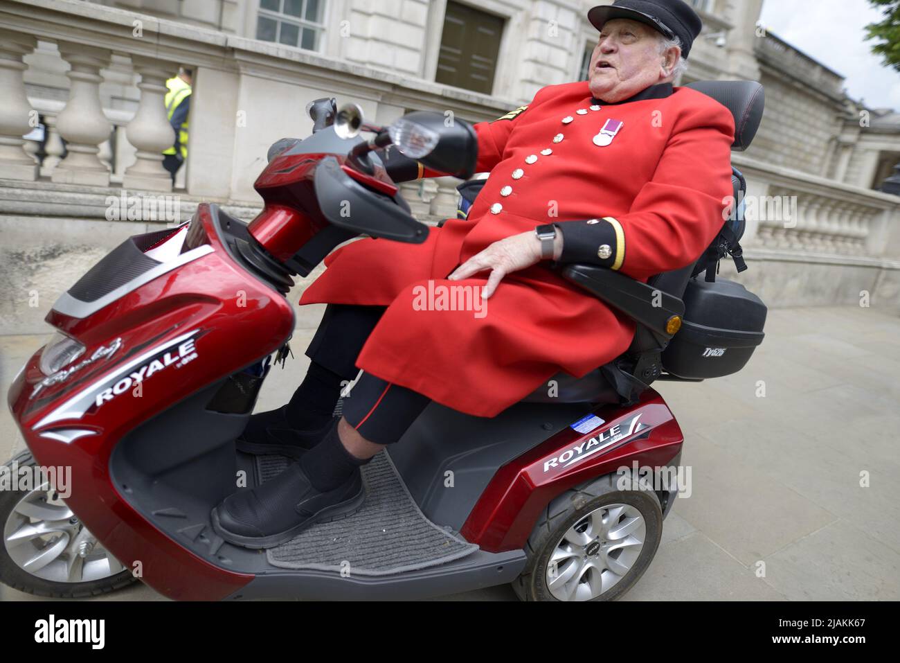 London, England, UK. Chelsea Pensioner using a mobility scooter in Whitehall, Westminster Stock Photo