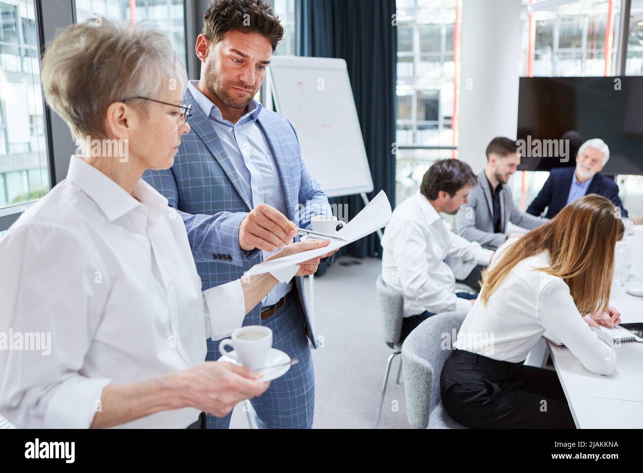 Two business people look at a protocol or a contract together in a ...