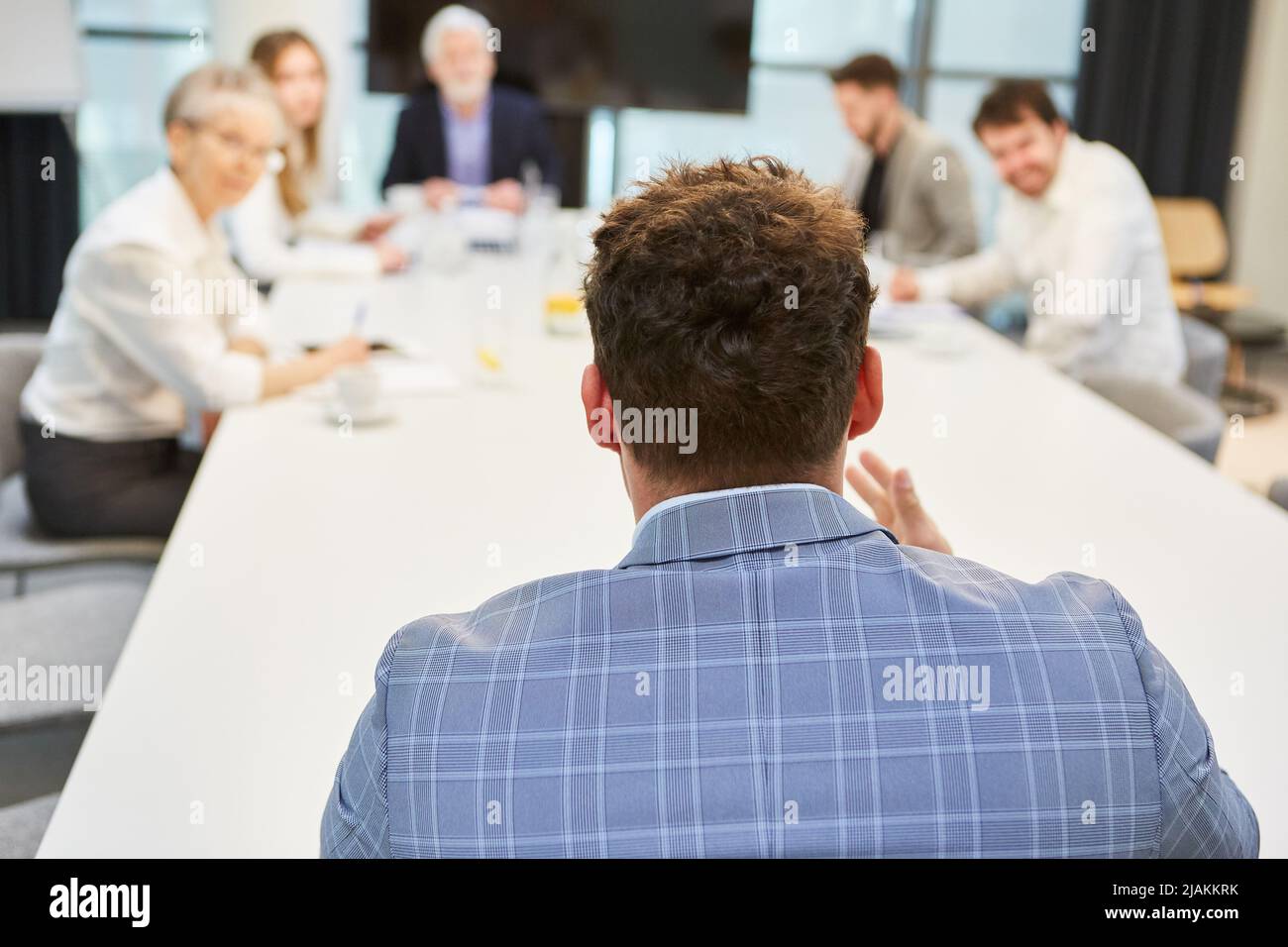 Businessman as applicant at job interview with employer at conference table Stock Photo