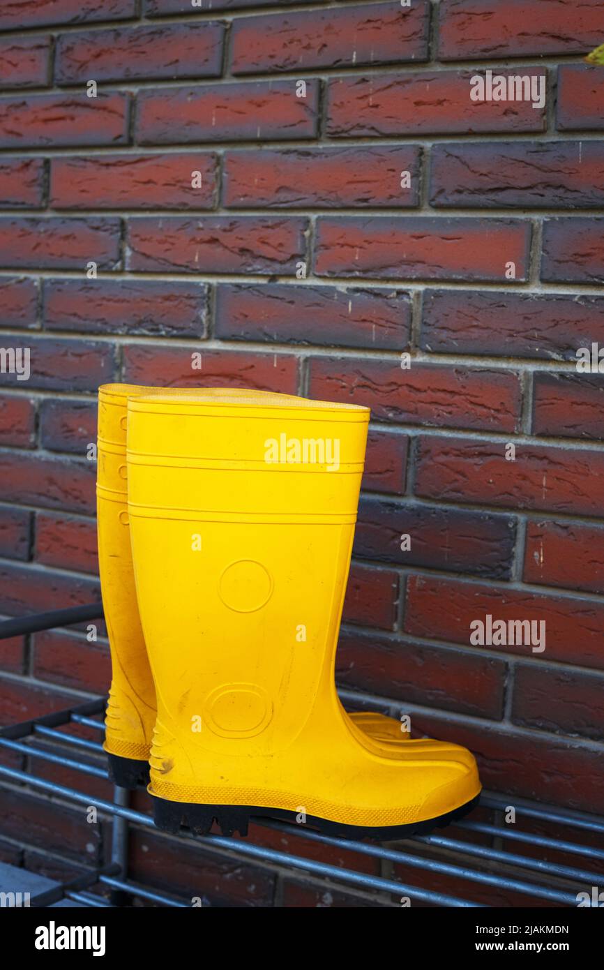 yellow rubber boots near the entrance to the house Stock Photo